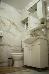 沙巴茨La Mirage的白色的浴室设有卫生间和水槽。
