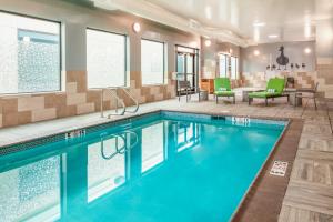 贝尔蒙Homewood Suites By Hilton Belmont的游泳池位于酒店客房内,配有桌椅