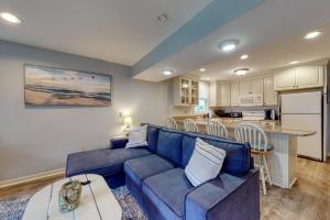 约克Long Sands Escape的一间带蓝色沙发的客厅和一间厨房