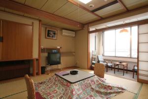 富士河口湖山田日式旅馆的客厅配有桌子和电视