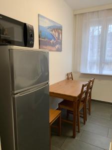 柏林Just Berlin - Wohnung für bis zu 12 Personen的厨房配有不锈钢冰箱和木桌