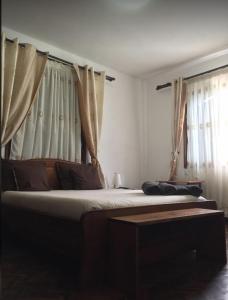塔那那利佛意阿瑞姆巴托酒店的一间卧室配有两张床和窗帘