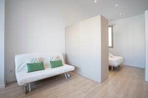 巴塞罗那BcnStop Sant Pau Suites的客房内的白色椅子和两个枕头
