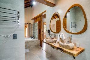 蒙特韦尔迪Pousada Jardim Monte Verde的浴室设有2个水槽和2个镜子
