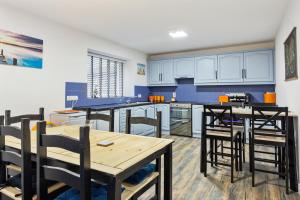 巴利卡斯尔Ballycastle Bolthole的厨房配有蓝色橱柜和木桌及椅子