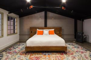 佩塔卢马Petaluma Warehouse Lofts unit E的卧室配有带橙色枕头的地毯。