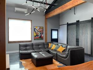 佩塔卢马Petaluma Warehouse Lofts unit E的客厅配有真皮沙发和黄色枕头。