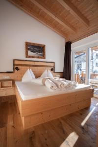 瑙德斯Palazi Apartments & Spa的一间卧室配有一张大木床和白色床单