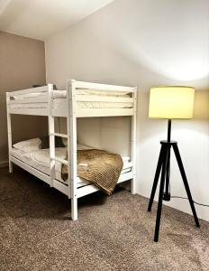 卢肯瓦尔德Haus Gitta II的配有灯的客房内的白色双层床