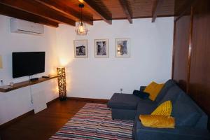 凡道Casa da Cantarinha的客厅配有蓝色的沙发和平面电视。