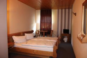 肖顿Berggasthof Hoherodskopf的酒店客房配有一张床铺和一张桌子。