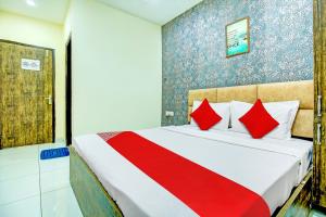 卢迪亚纳OYO Hotel Grace Villa的一间卧室配有一张带红色枕头的大床