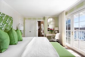 北哈特利Manoir Hovey, Relais & Châteaux的卧室配有带绿色枕头的大型白色床