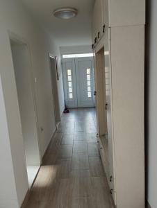 BrusVila Mihajlovic的一条空的走廊,有白色的门,铺着瓷砖地板