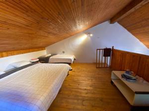LeunovoLeunovo Adventure Villa的一间卧室设有两张床和木制天花板
