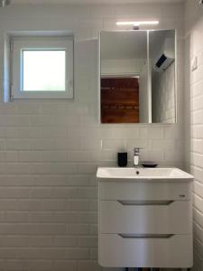 LeunovoLeunovo Adventure Villa的白色的浴室设有水槽和镜子