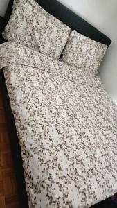 CugyCocooning House的一张带白色棉被和两个枕头的床