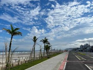 马蒂尼奥斯Lindo apartamento com vista para o mar的一条棕榈树海滩旁的道路