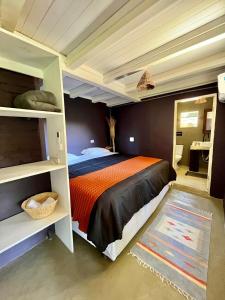 卡拉伊瓦Vila Patí Caraíva的一间卧室配有一张带橙色和黑色棉被的床