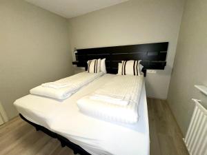 雷克雅未克Reykjavikurvegur 42的一张大白色的床,在房间里设有黑色床头板