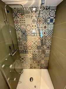 夏蒙尼-勃朗峰Gorgeous Mini-Chalet Chamonix的一间带淋浴的浴室和瓷砖墙