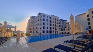 迪拜VIEVV Property Rentals的酒店设有带椅子和遮阳伞的游泳池