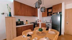 迪拜VIEVV Property Rentals的厨房配有木桌和黑冰箱。