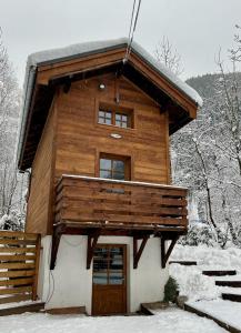 夏蒙尼-勃朗峰Gorgeous Mini-Chalet Chamonix的雪地里的小木屋,有门
