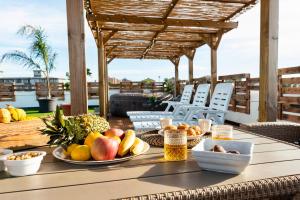 夸尔图-圣埃莱娜Secret Paradise & SPA Rooftop的露台上的一张桌子上放有水果盘