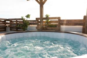 夸尔图-圣埃莱娜Secret Paradise & SPA Rooftop的庭院设有按摩浴缸和长椅