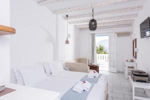 圣安娜纳克索斯Cycladic Islands Hotel & Spa的白色的客房配有两张床和一张沙发