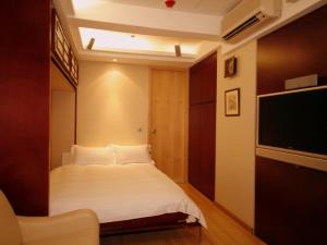 香港名樂居 At The Eden的一间卧室配有一张床和一台平面电视
