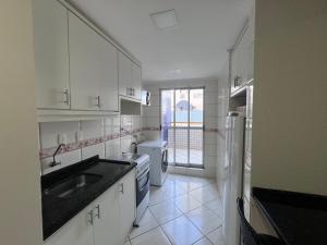 卡斯卡韦尔APTO no Centro, COMPLETO, UNIPAR e SHOPPING JL的白色的厨房配有水槽和冰箱