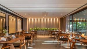 格拉玛多CHATEAU DU GOLDEN的餐厅设有木桌、椅子和窗户。