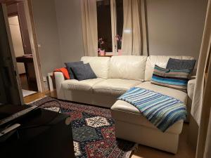 JärboLillhuset的客厅配有白色沙发和蓝色枕头。