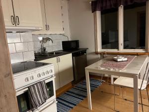 JärboLillhuset的厨房配有白色炉灶和桌子