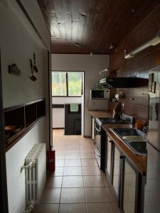 圣卡洛斯-德巴里洛切Casa centro Bariloche的厨房配有水槽和炉灶 顶部烤箱