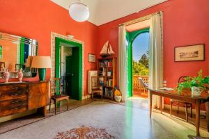 库特罗菲安诺Villa Sirgole 1897的客厅拥有橙色墙壁和绿色装饰