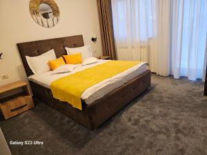 特尔古尼亚姆茨Străjerii Cetății的一间卧室配有一张带橙色和白色枕头的大床