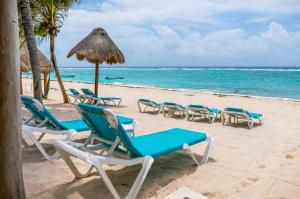 艾库玛尔Beachfront Hammock Heaven的海滩上的一组椅子和一把遮阳伞