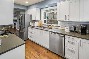 西雅图Cozy Cloverdale BY Betterstay的厨房配有白色橱柜和不锈钢用具