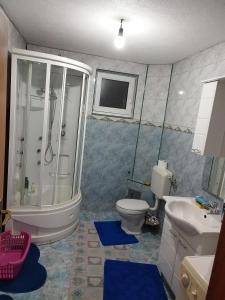 萨拉热窝Apartman Leki的带淋浴、卫生间和盥洗盆的浴室