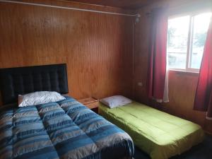 安库德EL URCO CHILOE HOSTEL的一间卧室设有一张床和一个窗口