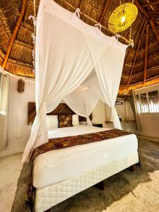 图卢姆Alito Tulum Hotel的天蓬客房的一张床位