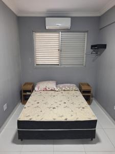 瓜鲁雅Cobertura Guarujá的一间卧室配有床和2个床头柜