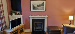 邓弗姆林Millhill St Dunfermline的客厅设有壁炉和电视。