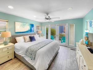 圣地亚哥Massive Mission Beach Home - Fire Pit & Deck的一间卧室设有一张大床和蓝色的墙壁