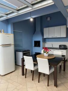 库里提巴Casa do Jardim的厨房配有桌椅和冰箱。
