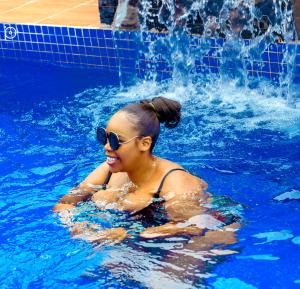 莱基Riviera Hotel, Apartments & Resorts的妇女在游泳池游泳