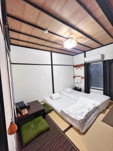 泉佐野比格汉姆之家住宿加早餐旅馆的一间带床的卧室,位于带窗户的房间内